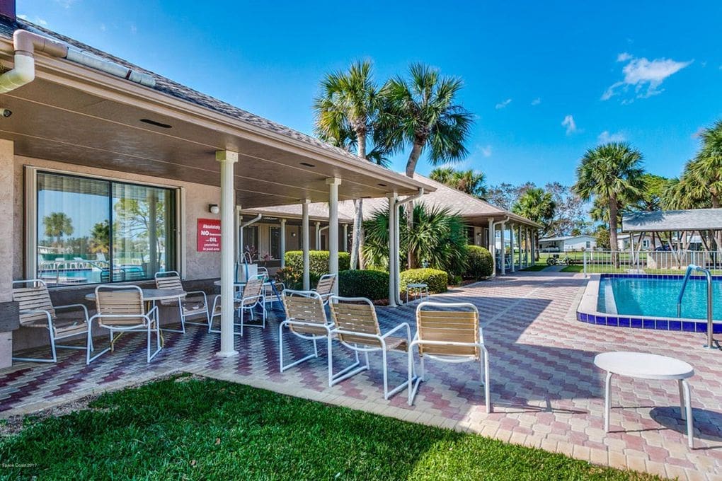 Outdoor pool area featuring lounge chairs, palm trees, and a sign prohibiting smoking. Ideal for relaxation and leisure activities.